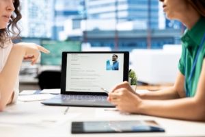 HR manager looking at CVs on tablet to vet selected applicants